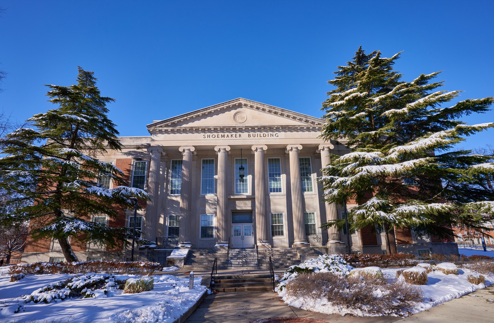 雪后的马里兰大学 Shoemaker Building、入口与树木