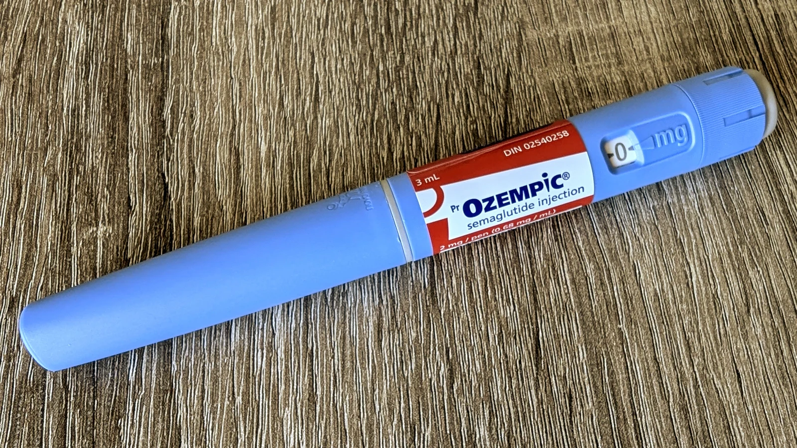 木纹台面上的蓝色司美格鲁肽注射笔。